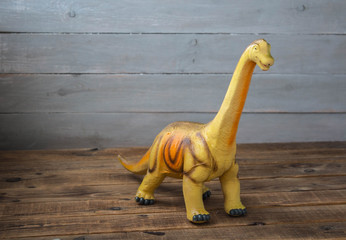 a big dinosaur children's toy on a wooden background