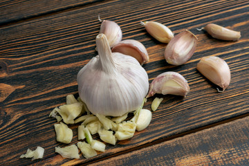 Garlic on wooden background. Minced garlic and whole cloves of garlic.
