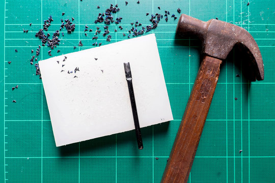 Hammer with tool for cut corner of leather on green cutting pad background