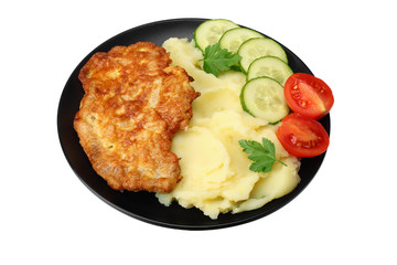 Mashed potatoes with schnitzel on black plate isolated on white background.