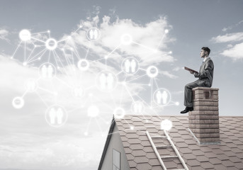 Man on roof reading book and concept of social connection