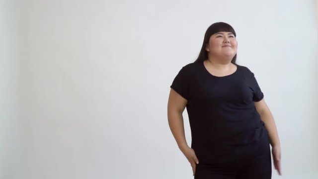 energetic Asian girl happy fatty dancing slow motion on a white background.