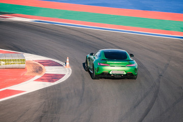 Beautiful green race car rides along race track