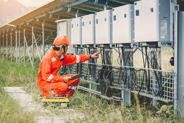 engineer or electrician holding laptop for inspect and checking string inverter by wifi technology...