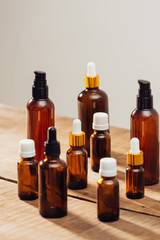 Essential oils bottles on wooden desk with candlelight beside. Spa wellness set.