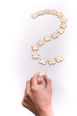 Hand holding the last piece of question mark. Question mark made from puzzle pieces on white background - 246123894
