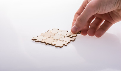 Hand completing a puzzle group on white background - 246124639