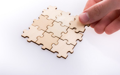 Hand completing a puzzle group on white background - 246124654