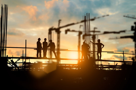 Silhouette of engineer and construction team working at site over blurred background for industry background with Light fair.Create from multiple reference images together