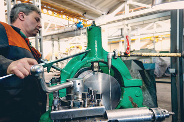 Turner measures the manufactured part of the measuring tool on the machine.