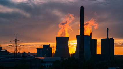 Fototapeta na wymiar Kamine von Kraftwerk im Sonnenuntergang am Sommerabend in Duisburg