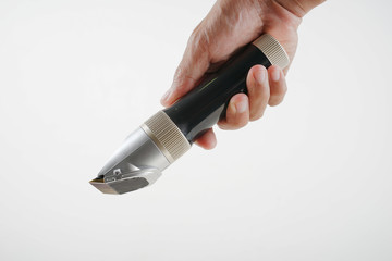 Asian hand in cropped holding shaving machine in white background. 