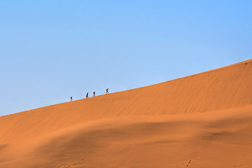 Fototapeta na wymiar climbing on a red dune in Namibia