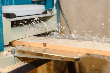 Wood processing on the machine. Flies shavings. Level the board. Joiner's tool.