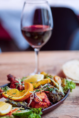 Traditional indian food tandoori chicken with red wine on a wooden table