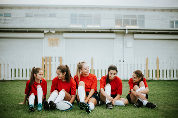 Happy female athletes resting on the grass