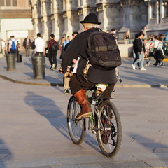 Fototapeta na wymiar Eccentric cycling in Duomo square, Milan, Italy.