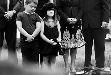 Sad grandkids standing by the grave