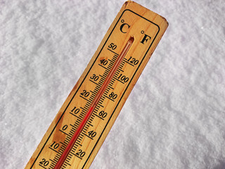 Termometr na śniegu pokazuje niskie temperatury poniżej zera w stopniach Celsjusza i Fahrenheita. Zimna zimowa pogoda dwadzieścia poniżej zera. - obrazy, fototapety, plakaty