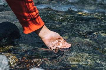 Woman scooping up water from the valley