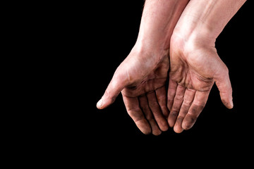 Dirty hands isolated on black background. Begging hands.