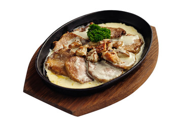 Sliced roasted meat with sauce in cast iron pan