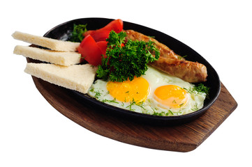 Breakfast with eggs, sausage and vegetables in cast iron pan