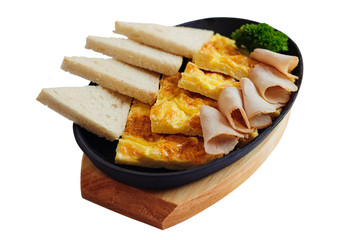 Breakfast with omelette, ham and bread in cast iron pan