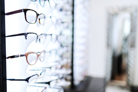 Eyeglasses sorted in line on shelf at optician.