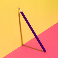 Purple school pencil on a pink yellow background. Modern conceptual art.