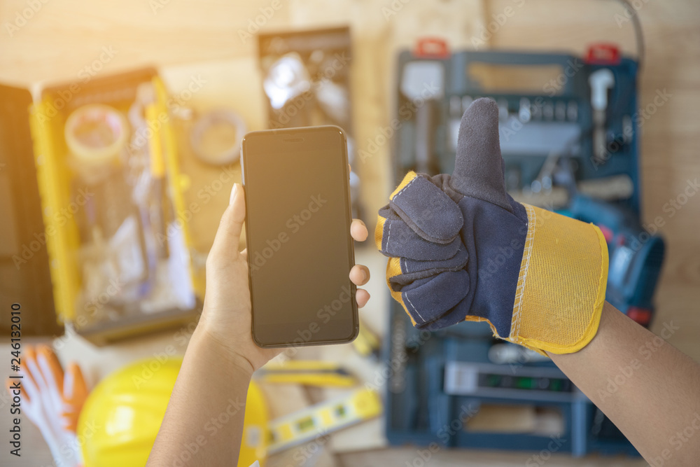 Wall mural telephone and hand wearing gloves and professional tools as a background