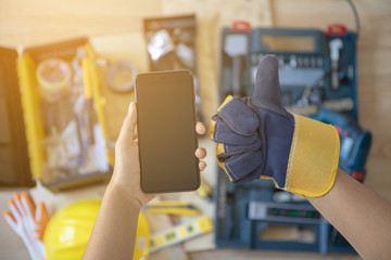 Telephone and Hand wearing gloves And professional tools as a background