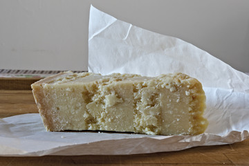 formaggio parmigiano su tagliere con incarto