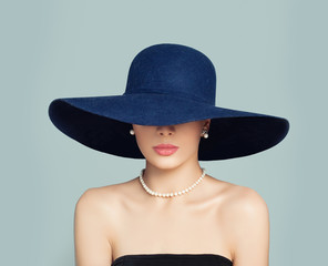 Elegant female model in blue hat, classic style fashion portrait