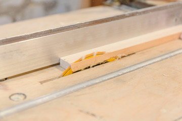 Saw the tree in the home workshop. A man sawing boards.