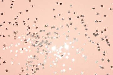 Fototapeta na wymiar Silver glitter stars on pink background in vintage colors