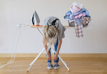 Exhausted woman lying on ironing desk