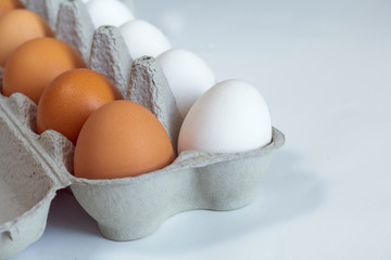 chicken eggs in a cardboard tray on background