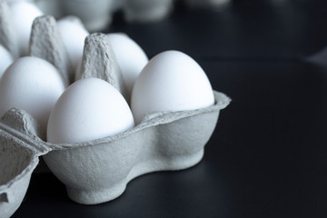 chicken eggs in a cardboard tray on background