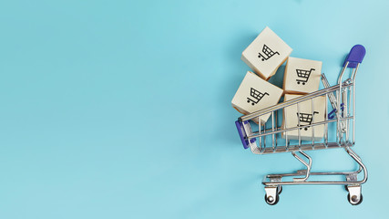 Boxes in a shopping cart on blue background. Concept: online shopping, e commerce and delivery of...
