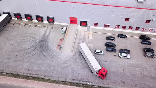 Big distribution warehouse with gates for loads and trucks Reversing Into A Loading Dock. Aerial Shot