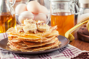 Thin pancakes with banana, walnuts and honey