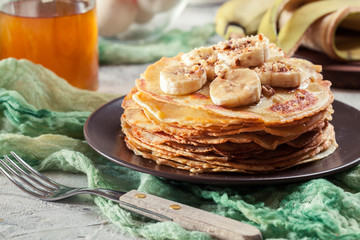 Thin pancakes with banana, walnuts and honey