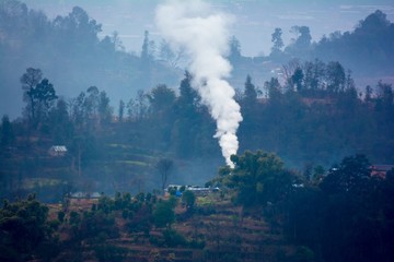 Fototapeta na wymiar Winter fire smoke in a small remote hilly village of Nepal