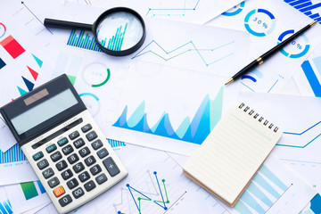 Naklejka na ściany i meble Calculator and Magnifying with Business Graphs finance document.