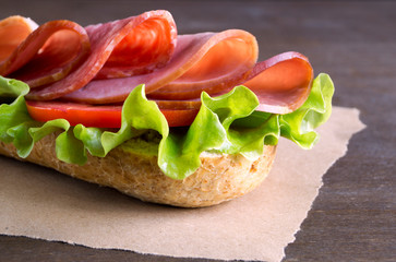 Sandwich with salami, ham and salad.
