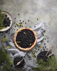 A blueberry cheesecake with blueberries on light green background. Vintage dishes and textile. Autumn flatlay