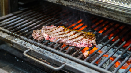 Cooking beef steak on a barbecue grill. Restaurant, chef. Open fire Coal.