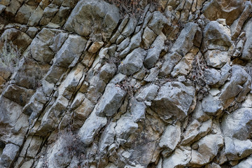 Close-up natural grey layered mountain breed as background.