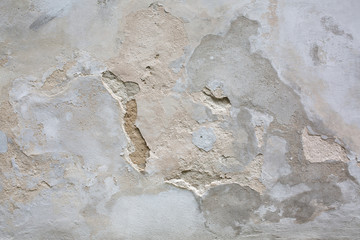 Outdoor shot of aged grey cement wall with cracks